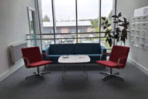 meeting area with chairs and sofa against a large floor to celing window 